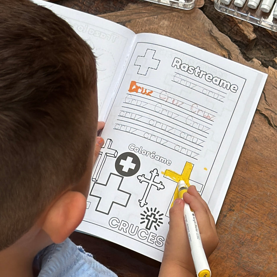Child coloring the shape cross in spanish from Preschool Essentials Trace Lines, Colors, Shapes and Numbers Coloring Book from Ermenrich Designs. Ages 3 and up.
