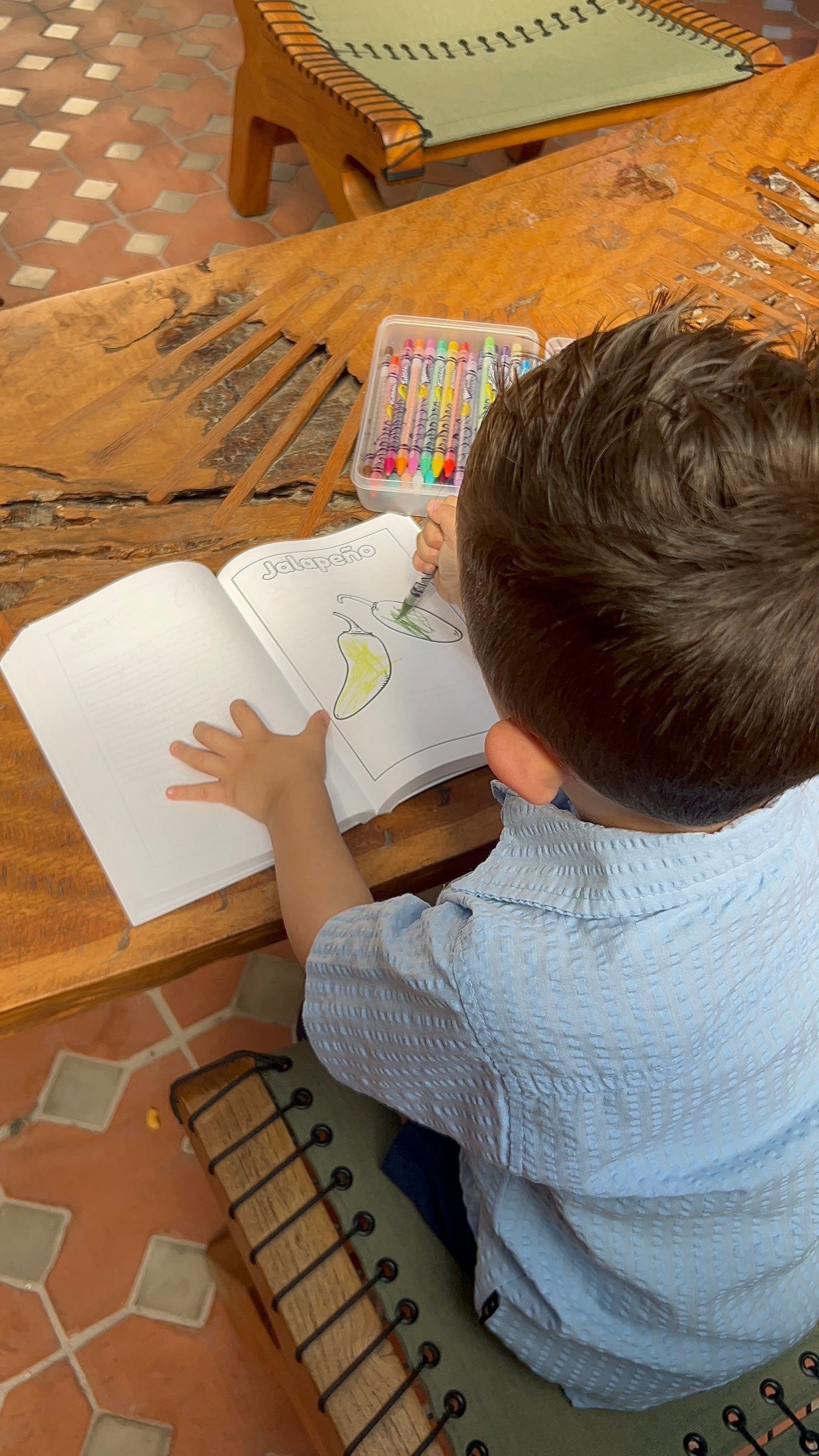 child coloring a page from Fruit or Vegetable? coloring book from Ernenrich Designs