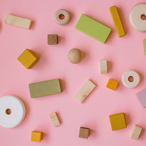 wooden shapes on a pink background